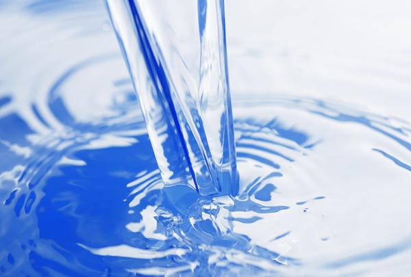 Clear water pouring into blue container